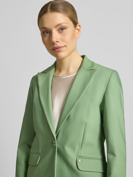 Frauenmodel trägt Regular Fit Blazer mit Pattentaschen Modell 'Blake' von MOS MOSH in Grün aus Baumwoll-Mix mit Stretch-Anteil, Nahaufnahme Oberkörper.