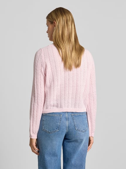 Frauenmodel trägt Regular Fit Pullover mit gerippten Ärmelbündchen Modell 'ADA' von PIECES in zartem Rosa und blauer Jeans, Ganzkörperansicht Rückansicht.