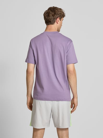 Männermodel trägt T-Shirt mit Logo und Rundhalsausschnitt von New Balance aus reiner Baumwolle, Regular-Fit, Rückenlänge 74 cm, Ganzkörperansicht Rückansicht.