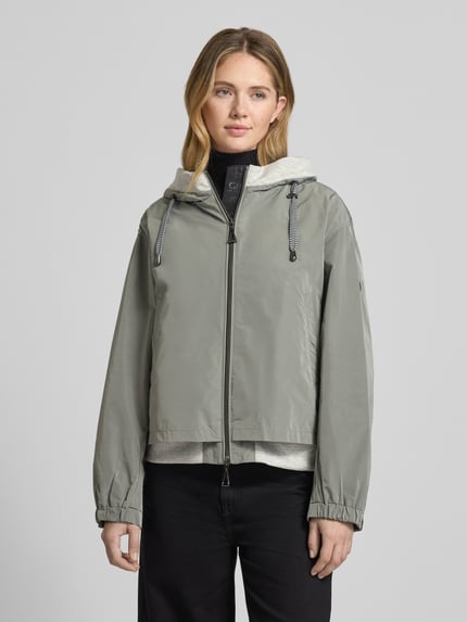 Kobiece modelka nosi kurtkę 'Jacke mit Zweiwege-Reißverschluss' od Gil Bret w kolorze szarym, krój relaxed fit, kaptur z tunelem, wpuszczane kieszenie, długość tyłu w rozmiarze 36: 59 cm, szerokość ramion w rozmiarze 36: 52 cm, szerokość w rozmiarze 36: 57 cm, długość rękawów w rozmiarze 36: 57 cm, widok na cały przód.