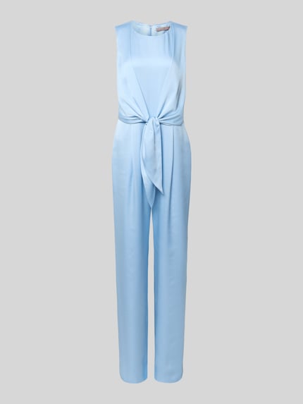 Frauenmodel trägt Jumpsuit aus Satin mit Bindegürtel von Christian Berg Cocktail in Hellblau, leicht tailliert, Ganzkörperansicht von vorne.