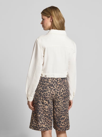 Modelka prezentuje kurtkę jeansową o krótkim kroju 'Cropped Jeansjacke mit Brusttaschen und Label-Patch' od Guess Jeans, mieszanka bawełny i lyocellu, krój straight fit, kołnierzyk typu kent, zamek błyskawiczny, kieszenie na piersi, naszywka z logo, kolor jasny, gładka tekstura, długość tyłu w rozmiarze S: 44 cm, szerokość ramion: 44 cm, szerokość w rozmiarze S: 52 cm, długość rękawów: 63 cm, widok całej sylwetki z tyłu.