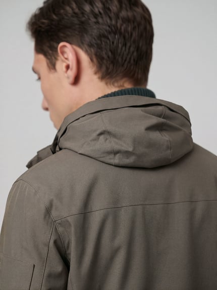 Männermodel trägt Parkamantel mit Kapuze OW_Hexatech Parka von BOSS, Struktur, unifarben, Detailaufnahme Rückansicht.