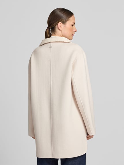 Frauenmodel trägt Mantel aus Lanawolle-Mix mit Eingrifftaschen von White Label in hellem Beige, texturierte Oberfläche, Ganzkörperansicht Rückansicht. Rückenlänge 85 cm, Schulterbreite 43 cm, Brustweite 58 cm, Ärmellänge 62 cm, gerader Schnitt, Stehkragen mit Kordelzug, verdeckter Verschluss.