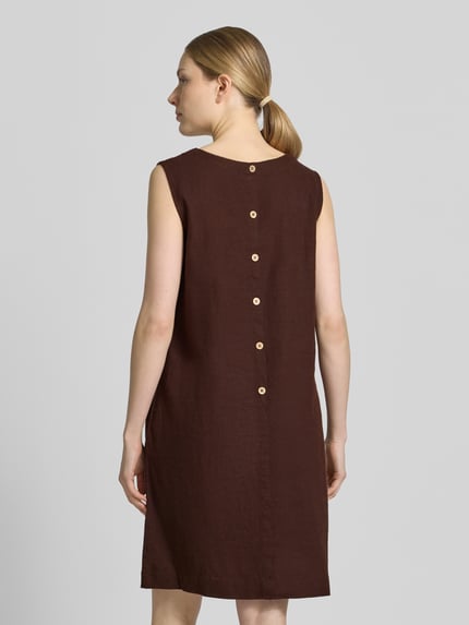 Frauenmodel trägt knielanges Kleid aus Leinen-Viskose-Mix Modell 'LAVA' von FREE/QUENT in Braun mit runden Knöpfen, Rückenansicht. Gerader Schnitt, Rundhalsausschnitt, glatte Textur, Kontext: Damen Kleid Leinen-Viskose-Mix, Knielänge, Rundhalsausschnitt, Rückenlänge 95 cm, Brustweite 50 cm. Ganzkörperansicht Rückansicht.