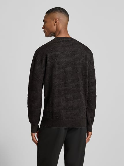 Männermodel trägt Strickpullover mit gerippten Abschlüssen von ARMANI EXCHANGE, dunkler Baumwoll-Material-Mix, lockerer Schnitt, Ganzkörperansicht Rückansicht.
