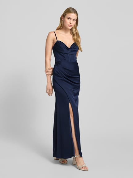 Frauenmodel trägt Abendkleid aus Satin mit Raffungen von Hey Kyla in Dunkelblau, A-Linie, Maxilänge, Gehschlitz, Ganzkörperansicht von vorne.