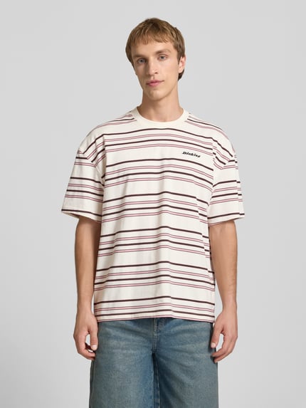 Mężczyznamodel nosi T-Shirt mit Logo-Stitching Modell 'EAST LIBERTY' od Dickies z bawełny, krój relaxed fit, okrągły dekolt, Ganzkörperansicht von vorne.