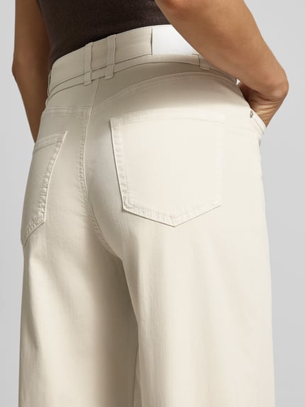 Frauenmodel trägt Wide Leg Hose mit Gürtel von Marc Cain, Baumwoll-Mix, cremefarben, strukturierte Oberfläche, Detailaufnahme Rückenansicht.