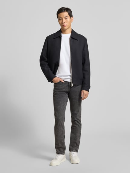 Męski model nosi Straight Fit Jeans aus Baumwoll-Mix Modell 'DELAWARE BO' od BOSS Orange, melanżowy denim, pełny widok z przodu.