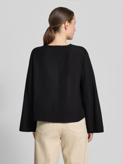 Frauenmodel trägt Blusenshirt aus Viskose-Mix mit Schnürung von Vila, schwarze Farbe, Regular-Fit, Modell 'PRISILLA', Ganzkörperansicht Rückansicht.