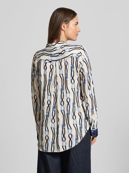 Frauenmodel trägt Hemdbluse mit Knopfleiste von Eterna aus reiner Viskose im lockeren Schnitt, Muster in Blau- und Beigetönen, Ganzkörperansicht Rückansicht.