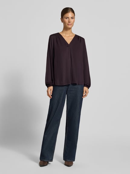 Vrouwenmodel draagt Regular Fit Bluse aus Viskose mit V-Ausschnitt van COMMA, donkerpaars, gladde textuur, plooidetail, voorkant volledig zichtbaar, Ganzkörperansicht von vorne.