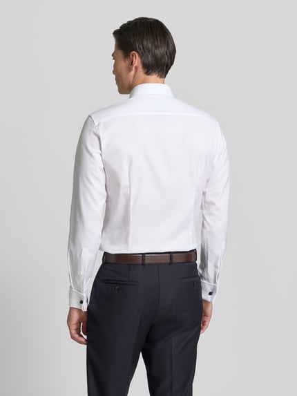 Männermodel trägt Slim Fit Businesshemd aus Twill von Jake*s in Weiß, Kentkragen, Umschlagmanschette, glatte Struktur, Ganzkörperansicht Rückansicht.