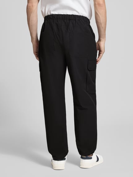 Männermodel trägt Regular Fit Hose mit Cargotaschen Modell 'LOGAN' von Antony Morato, schwarzer Baumwoll-Mix, Rückansicht Ganzkörperansicht.
