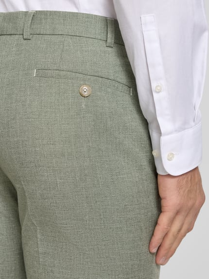 Männermodel trägt Moden Fit Anzughose mit Bügelfalten Modell 'Sergio' von DIGEL, grün, Material-Mix mit Viskose-Anteil, Detailaufnahme Rückansicht, Gesäßtaschen, Bundweite 49 cm, Innenbeinlänge 82 cm bei Größe 50.
