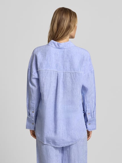 Frauenmodel trägt Regular Fit Hemdbluse aus reinen Leinen von Christian Berg Woman in Hellblau mit Fransenbesatz, Ganzkörperansicht Rückansicht. Damen Hemdbluse mit Hemdblusenkragen, durchgängiger Knopfleiste, Langärmelig, Rückenlänge bei Größe 36: 72 cm, Ärmellänge: 55 cm.