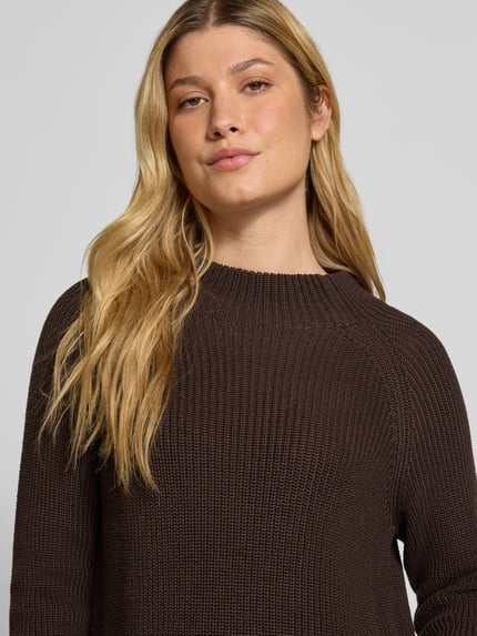 Frauenmodel trägt Strickpullover mit Stehkragen von monari, Baumwoll-Mix, Grobstrick in Dunkelbraun, Regular Fit, Nahaufnahme Oberkörper.