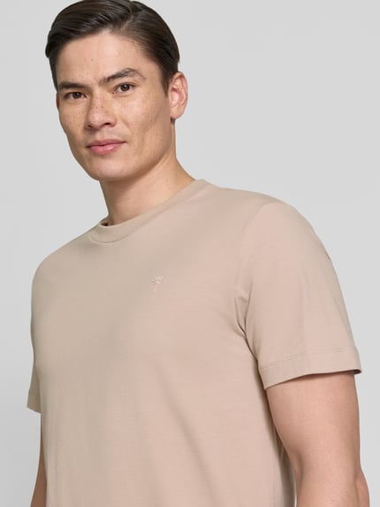Männermodel trägt T-Shirt mit Rundhalsausschnitt Modell 'Carlonito' von JOOP! Collection, beigefarbener Baumwoll-Mix, Nahaufnahme Oberkörper.