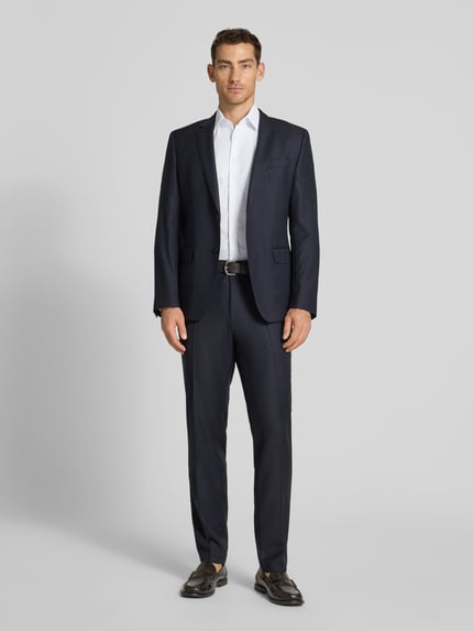 Męski model nosi Slim Fit Business-Hemd mit Kentkragen von Jake*s, biały kolor, bawełniana mieszanka z domieszką stretchu, krój slim fit, kent, zapięcie na guziki, długość pleców w rozmiarze 39/40: 83 cm, szerokość w rozmiarze 39/40: 41 cm, długość rękawa: 26 cm, całopostaciowe ujęcie od przodu.
