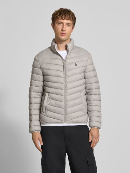 Männermodel trägt Regular Fit Steppjacke mit Logo-Stickerei von REVIEW in Stepp-Optik, Hellgrau, Reißverschluss, Ganzkörperansicht von vorne.