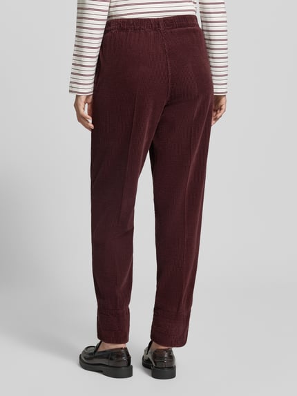 Frauenmodel trägt Straight Fit Hose aus reiner Viskose Modell 'Padow' von American Vintage mit Strukturmuster, elastischem Bund, Ganzkörperansicht Rückansicht.
