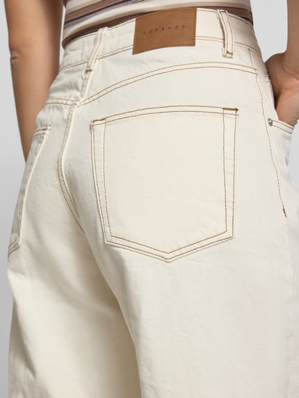 Männermodel trägt Barrel Fit Jeans Modell 'ALMA' von Topshop aus bawełna, wpuszczane kieszenie, kremowy odcień, detal tylnej kieszeni, Nahaufnahme tylnego obszaru. Szerokość w rozmiarze 28/32: 36 cm, długość wewnętrzna nogawki: 77 cm.