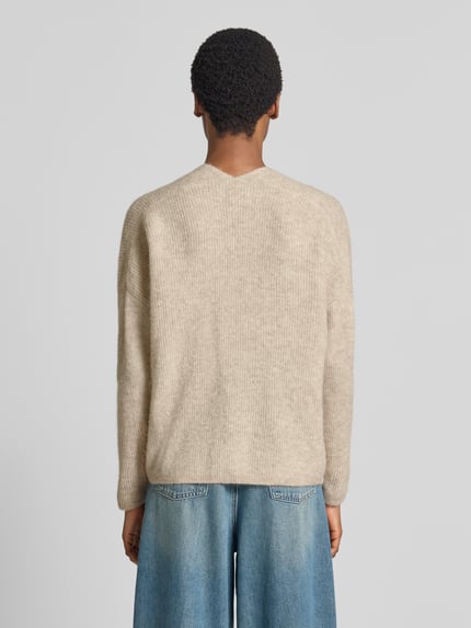 Vrouwenmodel draagt gebreide pullover uit wolmix met alpaca, regular fit, v-hals, Model 'THORA' van MOS MOSH, ruglengte maat S 82 cm, mouwlengte maat S 46 cm, lichte beige tint, subtiele ribstructuur, model van achteren volledig zichtbaar, Ganzkörperansicht Rückansicht.