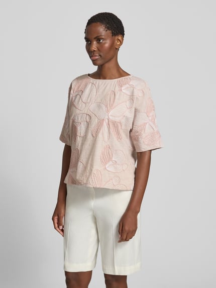 Frauenmodel trägt Blusenshirt aus reiner Baumwolle von Christian Berg Woman, Damen Kurzarmbluse im Allover-Look mit Stitchings und Rundhalsausschnitt, Regular-Fit, zartes Rosa mit dezentem blättrigem Muster, Rückenlänge 55 cm, Ärmellänge 29 cm, Ganzkörperansicht von vorne.