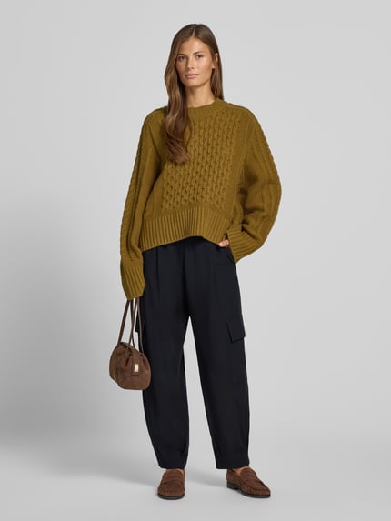 Frauenmodel trägt Cargo-Hose mit weitem Bein – curated by Vera van Erp von Style Icon Collection, locker geschnitten, schwarze Stoffhose mit französischen Eingrifftaschen, Pattentaschen und Gesäßleistentaschen, Material-Mix mit Viskose-Anteil, Knopf- und Reißverschluss, glatte Textur, Ganzkörperansicht von vorne.