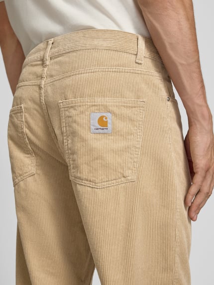 Männermodel trägt Straight Fit Hose aus reiner Baumwolle in Cord-Optik von Carhartt Work In Progress, 5-Pocket-Design, Detailaufnahme Rückansicht.
