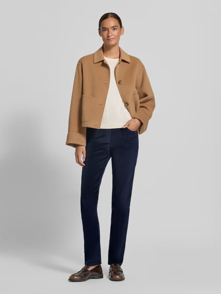Frauenmodel trägt Slim Fit Jeans aus Baumwoll-Viskose-Mix Modell 'Pamina' von Raphaela By Brax, dunkelblau mit glatter Textur, Ganzkörperansicht von vorne. Damen Slim Fit Jeans von Raphaela By Brax.