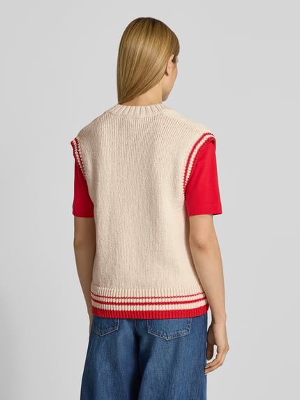 Vrouwenmodel draagt Loose Fit Pullunder uit katoenmix model 'ICONIC A COLLEGE' van Armedangels, effen kleuren, gebreide look, gestikt logo, contraststrepen, v-hals, rompzoom geribd, materiaalverwerking: knitwear, detailopname rugaanzicht