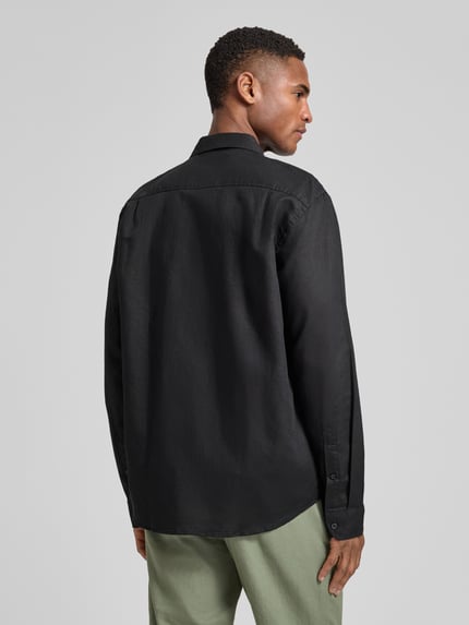 Männermodel trägt Regular Fit Freizeithemd aus Leinen-Baumwoll-Mix Modell 'CLAY LINENBLEND' von SELECTED HOMME in Schwarz, Melange-Optik, Flammgarn, 2-Knopf-Manschette, Rückansicht Ganzkörperansicht.
