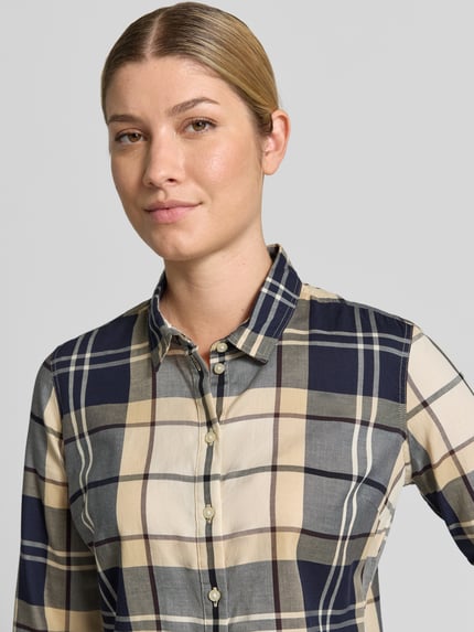 Frauenmodel trägt Regular Fit Hemdbluse aus reiner Baumwolle Modell 'BREDON' von Barbour, kariert in Beige, Blau und Creme, Nahaufnahme Oberkörper, Damen Hemdbluse von Barbour.