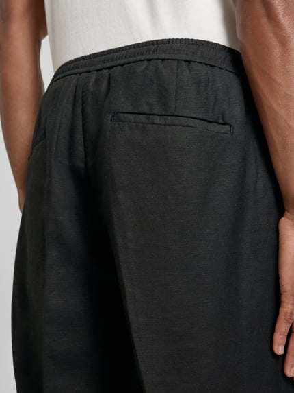 Männermodel trägt Shorts aus Leinen-Viskose-Mix Modell 'NEIL' von Antony Morato, schwarze Farbe, feine Struktur, Detailaufnahme Rückansicht, Herren Shorts, Regular-Fit, mit Bügelfalten und elastischem Bund, Bundweite 42 cm, Innenbeinlänge 17 cm, Größe 50.