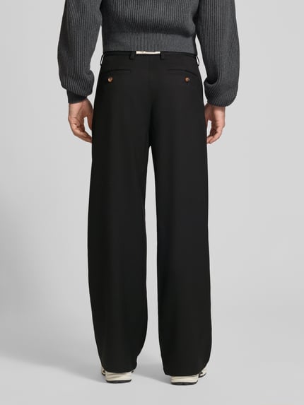 Mężczyzna nosi spodnie z zakładkami w pasie Bundfaltenhose mit Gesäßtaschen Modell 'HERITAGE' von PROHIBITED, Mieszanka materiałów z dodatkiem wiskozy, krój regular fit, kieszenie z tyłu, szerokość w rozmiarze M: 46 cm, długość wewnętrzna nogawki w rozmiarze M: 80 cm, czarne, gładkie, szerokie nogawki, Ganzkörperansicht Rückansicht.