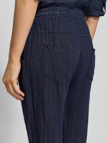 Frauenmodel trägt Leinenhose mit elastischem Bund Modell 'Pa44uline' von ZABAIONE in Dunkelblau, reine Leinen, Regular-Fit, Nahaufnahme Rückansicht.