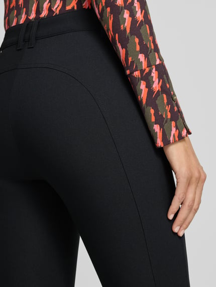 Vrouwenmodel draagt Slim Fit Schmale Hose met Viskose-Anteil Model 'SILEA' van Marc Cain, kleur effen zwart, deelnaad, labeldetail, riemlussen, ritszakken, materiaalverwerking met viscose, detailopname rugzijde