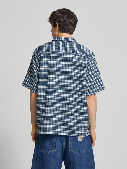 Männermodel trägt Regular Fit Freizeithemd aus reiner Baumwolle von Carhartt Work In Progress, kariertes Strukturmuster, Ganzkörperansicht Rückansicht.