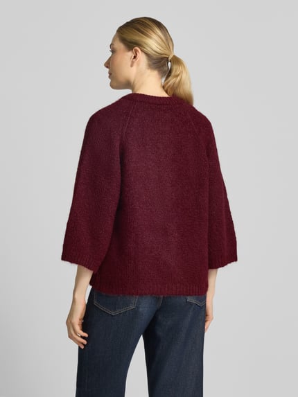 Männermodel trägt Relaxed Fit Cardigan mit Woll-Anteil Modell 'Lulu' von FREE/QUENT, elastyczna mieszanka materiałów z mieszanką wełny, imitacja dzianiny, rękaw o dł. 3/4, długość tyłu w rozmiarze S: 59 cm, długość rękawów w rozmiarze S: 48 cm, widok całej sylwetki od tyłu.