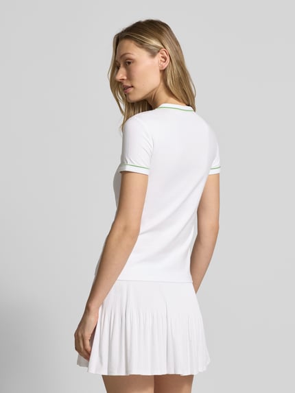 Frauenmodel trägt Slim Fit T-Shirt aus Baumwoll-Mix von Lacoste, unifarben mit Logo-Stitching und Kontrastpaspel, Ganzkörperansicht Rückansicht.