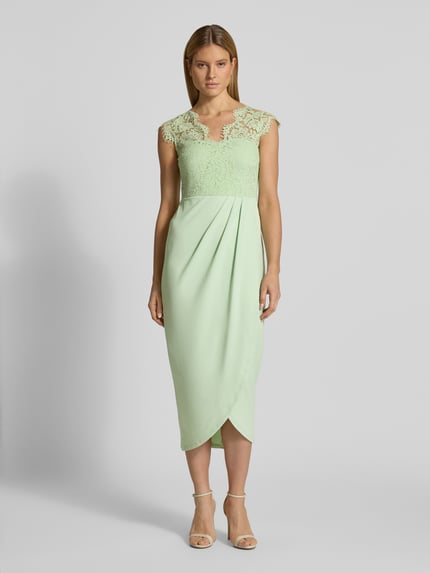 Frauenmodel trägt Midikleid mit Spitze Modell 'CLARA' von Vila in Mintgrün, taillierter Schnitt, V-Ausschnitt, Ganzkörperansicht von vorne.