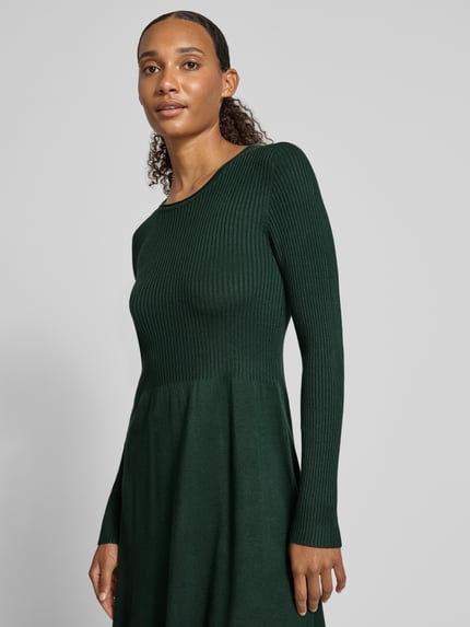 Frauenmodel trägt Regular Fit Strickkleid aus Viskose-Mix Modell 'ALMA' von ONLY in Dunkelgrün, Damen Strickkleid, Nahaufnahme Oberkörper.