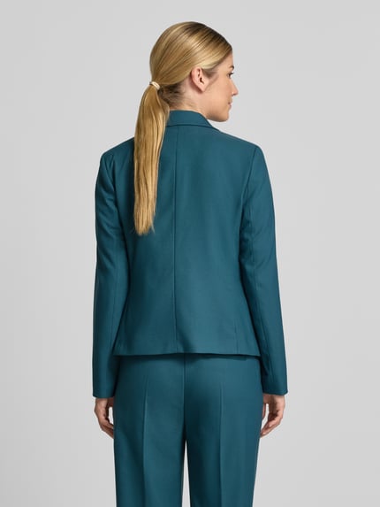 Frauenmodel trägt Slim Fit Blazer mit Paspeltaschen von COMMA in Türkis, Material-Mix mit Viskose-Anteil, Ganzkörperansicht Rückansicht.