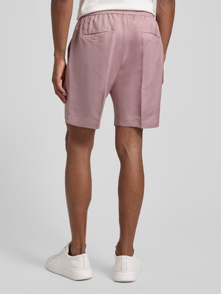 Männermodel trägt Shorts aus Leinen-Viskose-Mix Modell 'NEIL' von Antony Morato, mauve, Regular-Fit, Bügelfalten, elastischer Bund, Ganzkörperansicht Rückansicht.