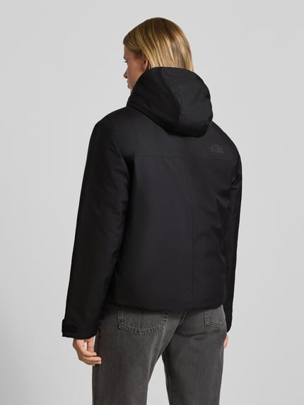 Frauenmodel trägt schwarze Jacke mit Logo-Stitching Modell 'RANGE DOWN' von The North Face, gerader Schnitt, Kapuze, Ganzkörperansicht Rückansicht.