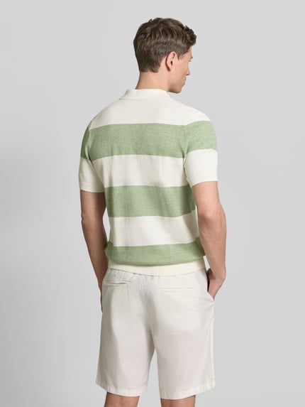 Männermodel trägt Slim Fit Poloshirt aus Baumwoll-Mix in Strick-Optik von OLYMP Level Five, breite grün-weiße Streifen, Kurzarm, Rückenansicht, Ganzkörperansicht Rückansicht.