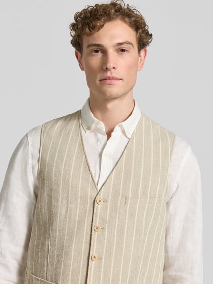 Mannelijk model draagt Regular Fit Weste met viscose-aandeel model 'Morley' van CG - Club of Gents, lichtbeige met streepstructuur, V-hals, knoopsluiting, paspelzakken, borstbreedte 42 cm, schouderbreedte 38 cm, bovenlichaam close-up.