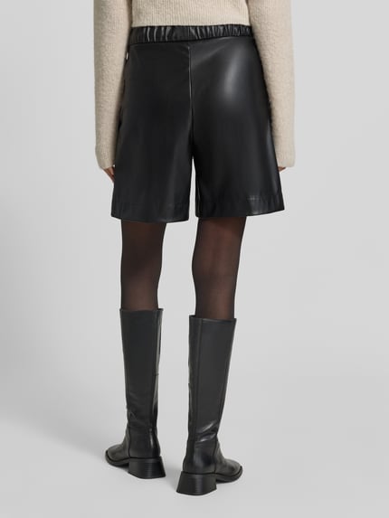 Frauenmodel trägt Wide Leg High Waist Bermuda aus Viskose-Mix Modell 'WILLMAR' von Marc Cain, Damen Jeansshorts, Ganzkörperansicht Rückansicht